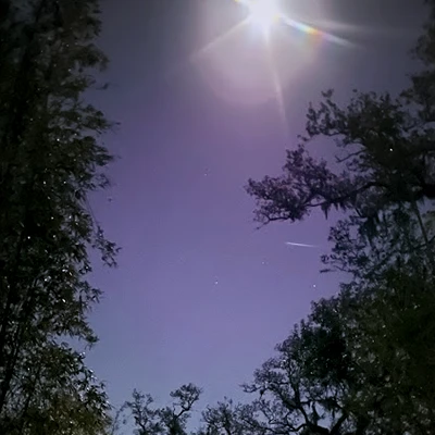Night time image of a full moon and shooting star 